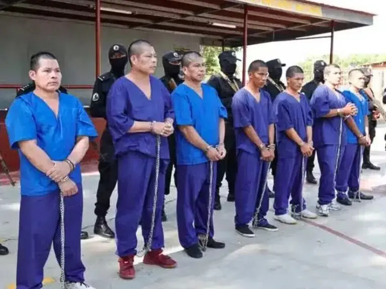 The image shows a row of imprisoned men in Nicaragua standing together in a row.