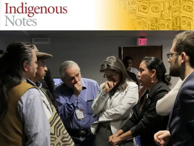 Image shows a group of people surrounding a woman who looks upset.