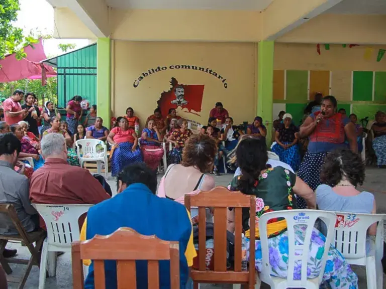 Image shows a group of people gathered in chairs.